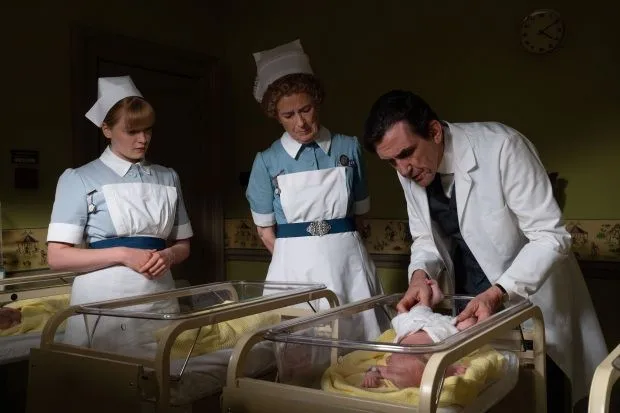 Midwives and a doctor examining a baby