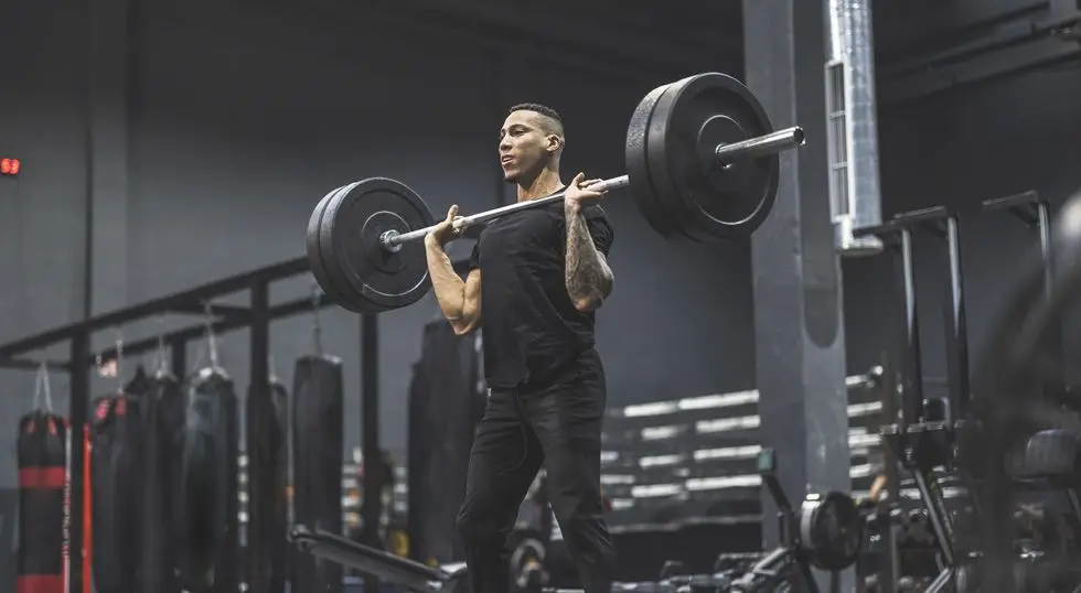 man working out in a gym with barbell and weights