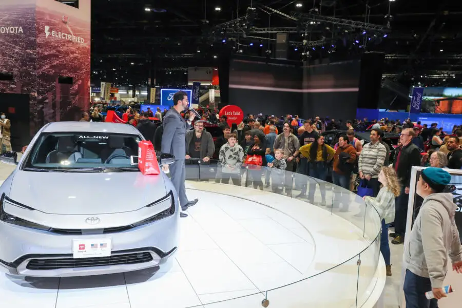 Crowds admire a car on display at the Chicago Auto Show