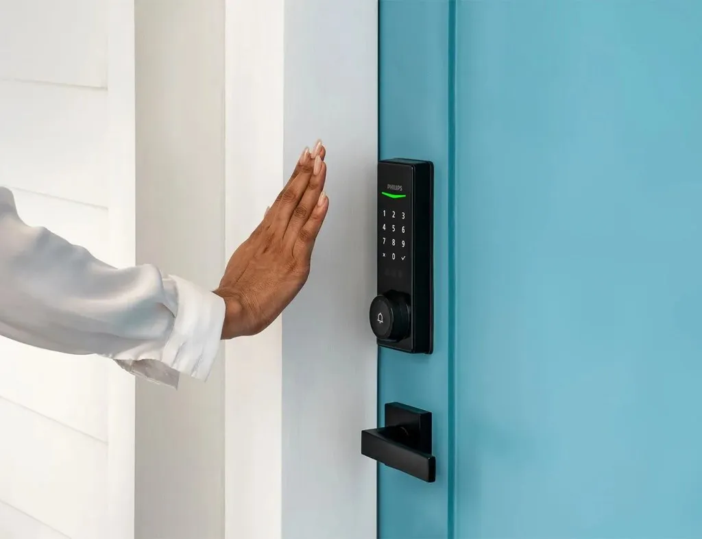 a hand reaching out to a door handle keypad