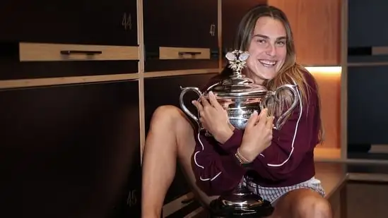 This handout picture released by Tennis Australia on January 27, 2023, shows Belarus' Aryna Sabalenka poses with the 2024 Australian Open women's singles final trophy at the locker room in Melbourne(AFP)