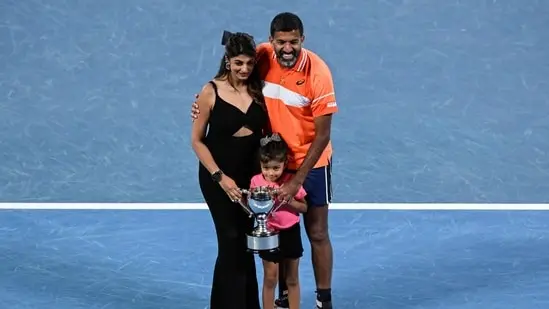 India's Rohan Bopanna poses with his family after victory against Italy's Simone Bolelli and Andrea Vavassori during their men's doubles final match on day 14 of the Australian Open tennis tournament in Melbourne on January 27(AFP)