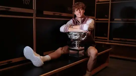 This handout picture released by Tennis Australia on January 29, 2024, shows Italy's Jannik Sinner poses with the 2024 Australian Open men's singles final trophy at the locker room in (AFP)