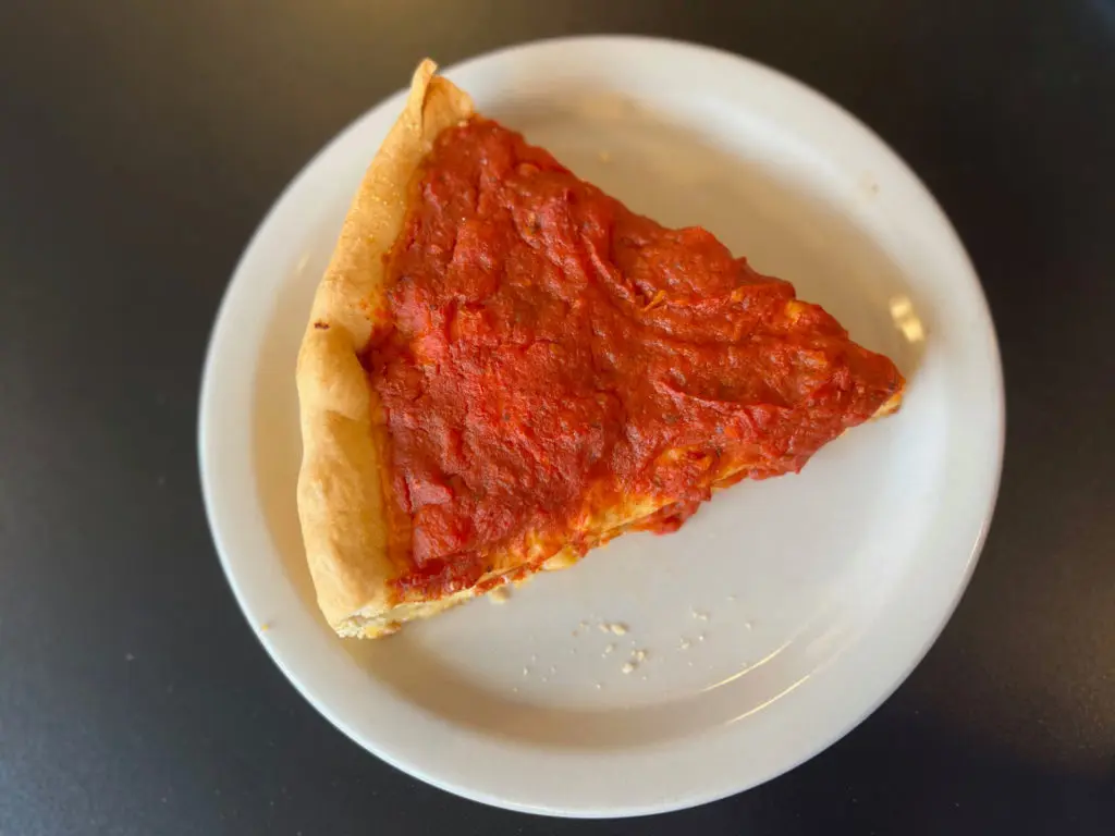 A slice of pepperoni deep dish pizza.