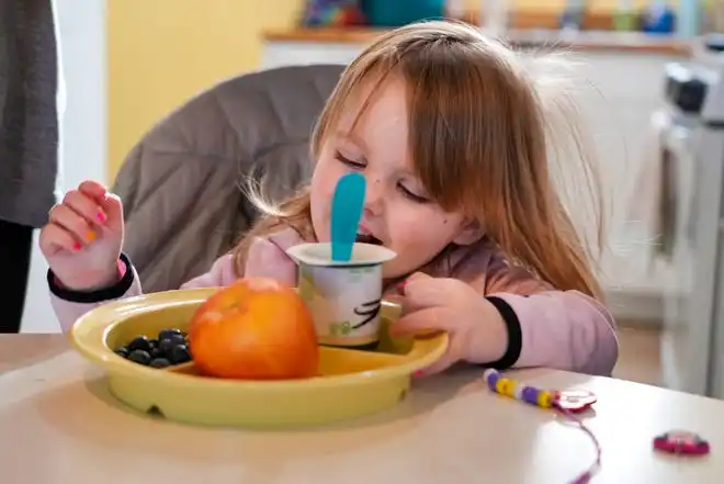 Missouri, 3. checks out the after-school snack her mom, Allison Reynolds, prepared for her on Jan. 17. The Reynolds family gets nutrition assistance from a US supplemental food program that could see a shortfall this year.