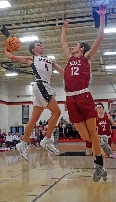 Albertville’s Samuel Barclift makes a shot as Boaz’s Brady Bouldin defends during high school basketball action in Albertville, Alabama January 29, 2024.