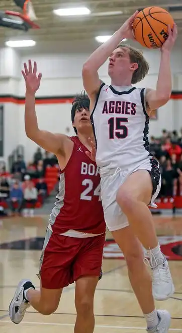 Albertville's Jacob Filteau makes a shot as Boaz's Fernando Vazquez defends during high school basketball action in Albertville, Alabama January 29, 2024.