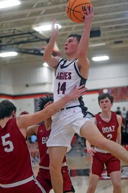 Albertville's Cooper Colvin makes a shot as Boaz's Tyler Sullivan defends during high school basketball action in Albertville, Alabama January 29, 2024.