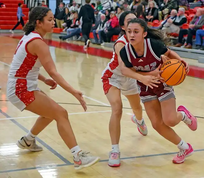 Boaz's Mollie Brock drives to the basket as Albertville's Dana Fuentes defends during high school basketball action in Albertville, Alabama January 29, 2024.