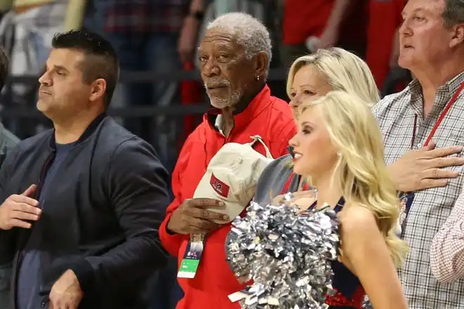 Jan 23, 2018; Oxford, MS, USA; Morgan Freeman (C) looks on during the national anthem prior to the game between the Mississippi Rebels and the Alabama Crimson Tide at The Pavilion at Ole Miss. Mandatory Credit: Spruce Derden-USA TODAY Sports