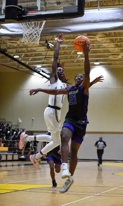 Okeechobee's Jaliek Brifil (21) attempts a layup over Treasure Coast's Bek Fleurissaint (0) in a boys high school basketball game, Tuesday, Jan. 30, 2024, in Port St. Lucie.