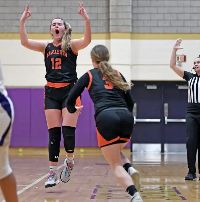 Sarasota's Sofi Miller (#12) scores a three-pointer against Booker at Tornado Alley in Sarasota.