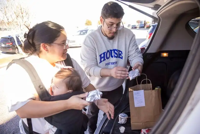 (From left) Kristen Soto carries 11-month-old Emeri as her and husband Luis Soto look...