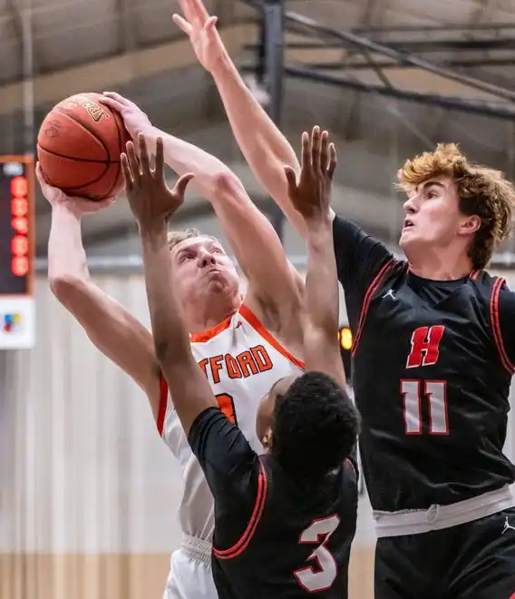 Hartford's RJ Thomae (3) looks for a shot against Homestead's Michael Rogers Jr. (3) and Jonah Wenzler (11) during the game at Hartford, Tuesday, Jan. 30, 2024.