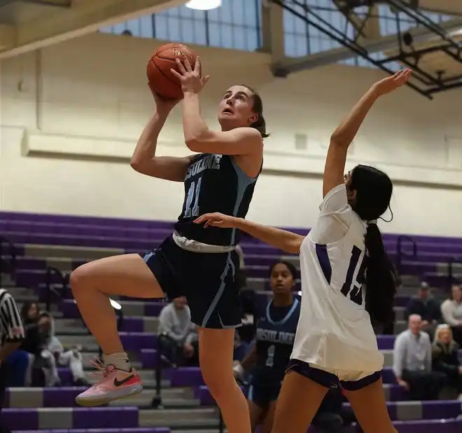 Ursuline's Meghan McDonald (11) drives on New Rochelle's Katelyn Samuel (15) during their 78-23 win in girls basketball action at New Rochelle High School on Wednesday, Jan. 31, 2024. McDonald has 12 points in the game