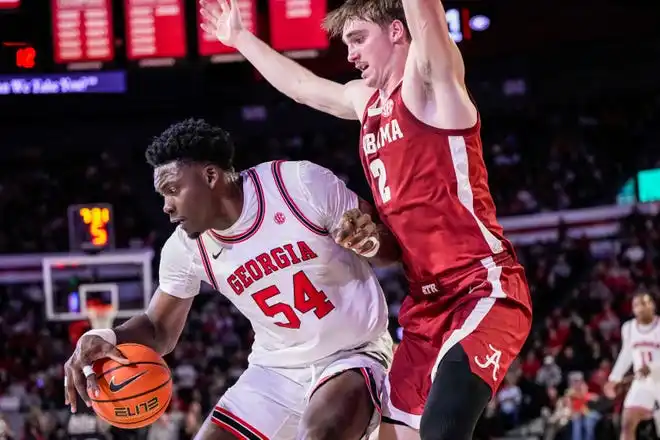 Jan 31, 2024; Athens, Georgia, USA; Georgia Bulldogs center Russel Tchewa (54) is defended by Alabama Crimson Tide forward Grant Nelson (2) during the first half at Stegeman Coliseum. Mandatory Credit: Dale Zanine-USA TODAY Sports