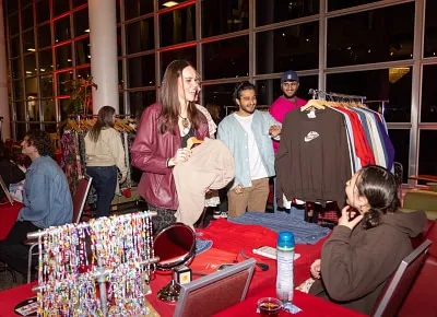 Gaby Hale (seated) sells a sweater during intermission at the 2nd Annual Fashion in Business runway show. Photo: John Barkiple