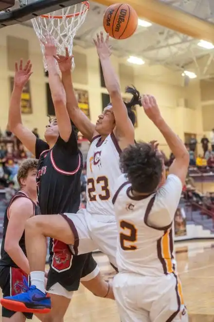 Cherokee’s Collin Ledford, center, attempts a shot as Andrews’ Cameron Rattler reaches for the ball, January 30, 2024.