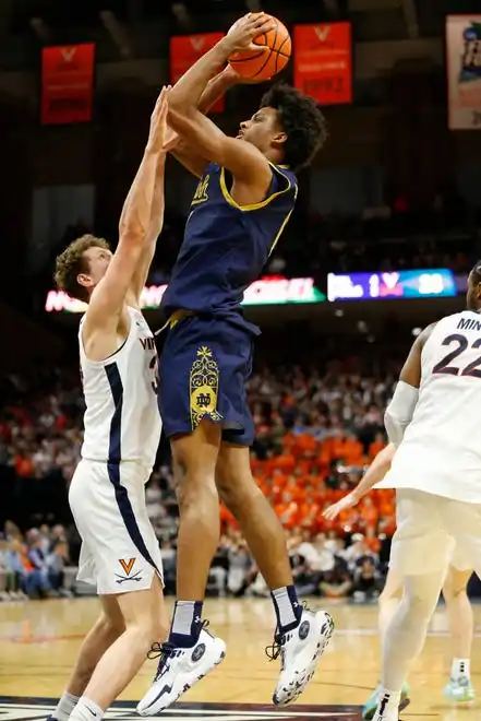 Jan 31, 2024; Charlottesville, Virginia, USA; Notre Dame Fighting Irish forward Carey Booth (0) shoots the ball over Virginia Cavaliers forward Jacob Groves (34) during the first half at John Paul Jones Arena. Mandatory Credit: Amber Searls-USA TODAY Sports