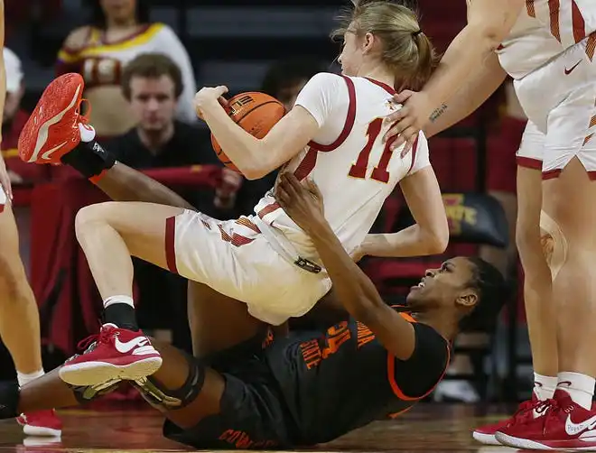 Iowa State Cyclones guard Emily Ryan (11) and Oklahoma State Cowgirls forward Praise Egharevba (24) battle for a loose ball during the first quarter in the Big-12 conference matchup at Hilton Coliseum on Wednesday, Jan. 31, 2024, in Ames, Iowa.