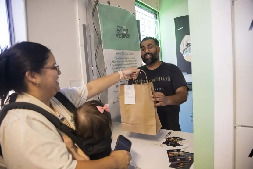 Kristen Soto carries 11-month-old Emeri as she grabs her Halal Fusionz’s, a Pakistani and...