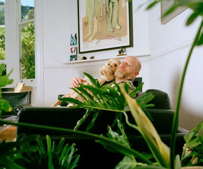 Hugo holding his skeleton figure from Cameroon. On the far left of the mantelpiece sits a sculpture by artist Damien Poulain. Above it hangs a painting by Moshekwa Langa