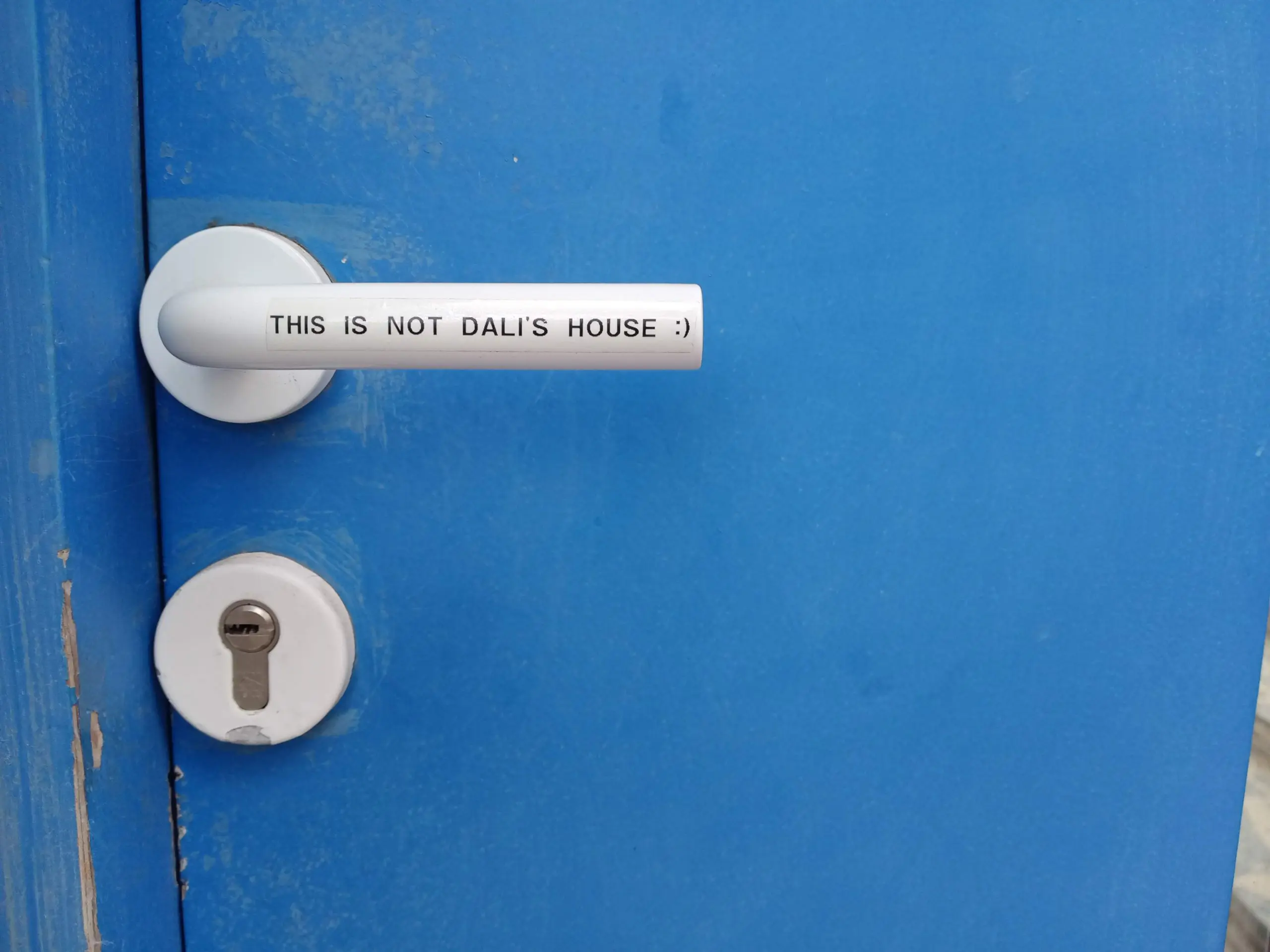 A white doorknob in a blue door
