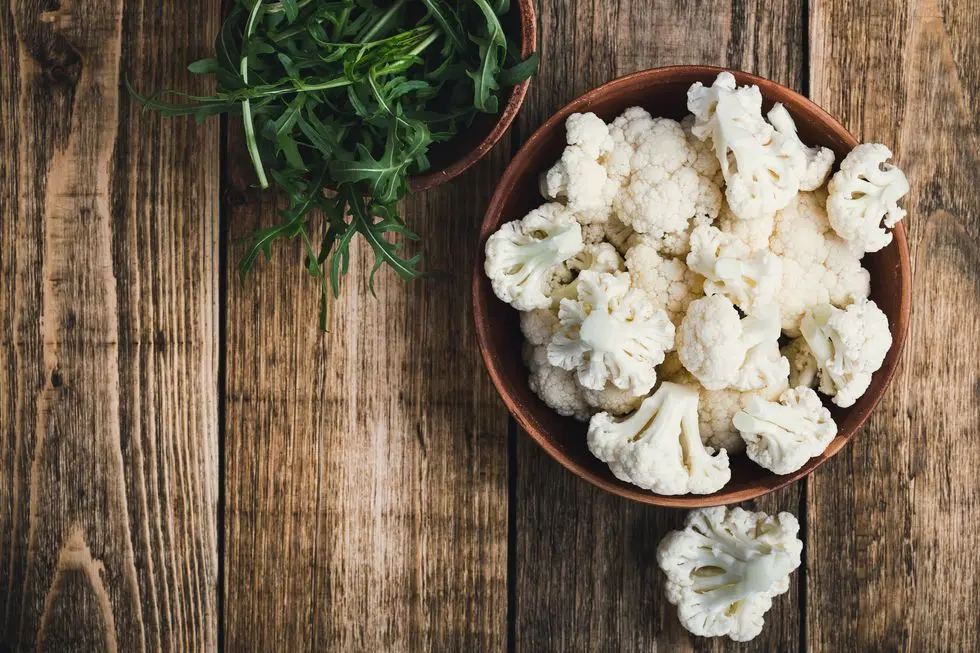 fresh organic cauliflower cut into small pieces in a bowl vegetarian recipe or menu background with copy space