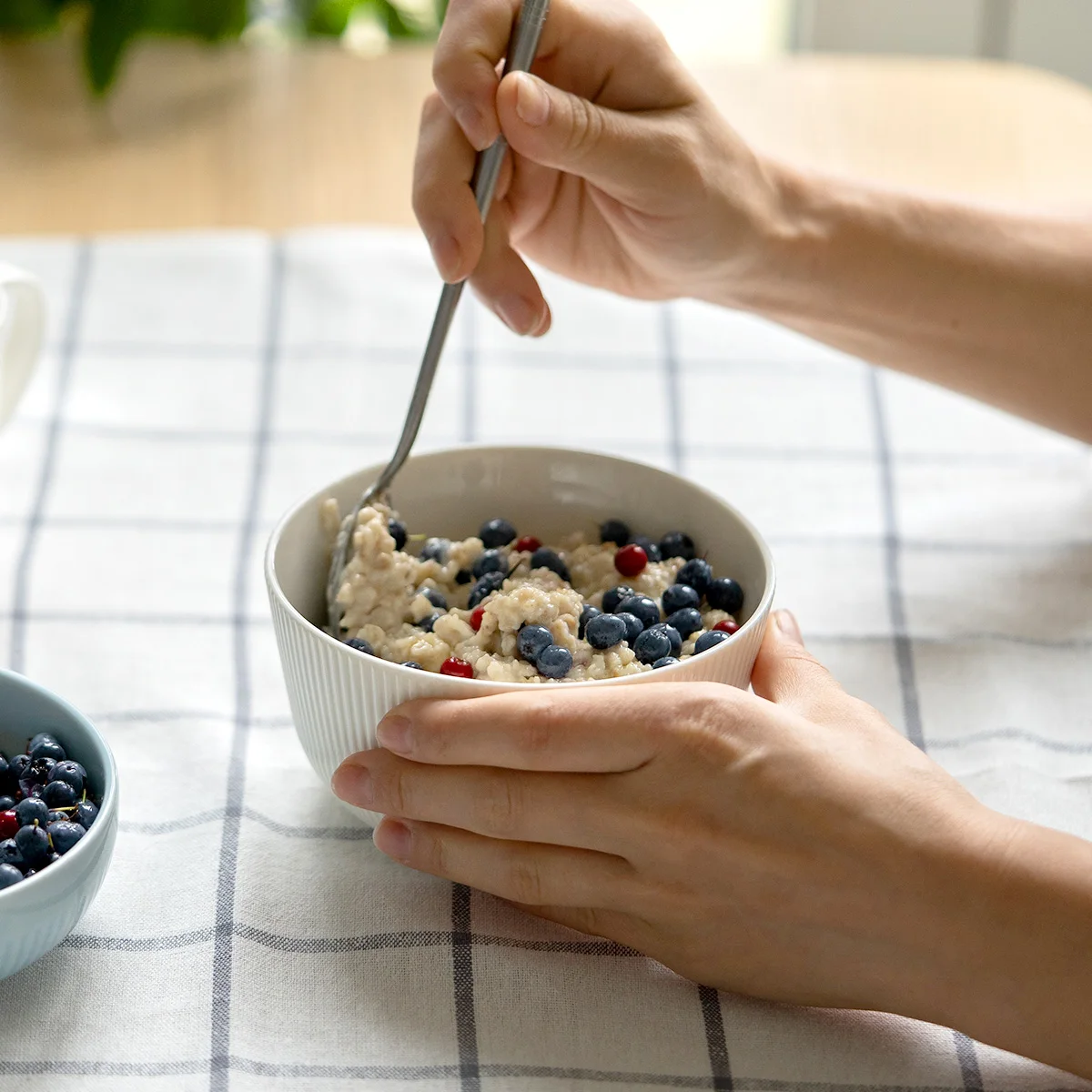 woman eating oatmeal with blueberries