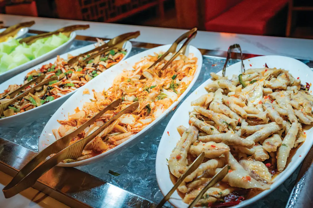 Kimchi and chicken feet on the appetizer buffet.