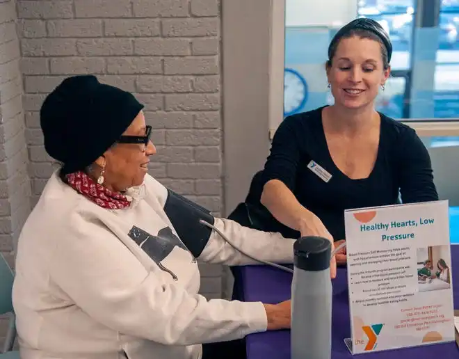 MetroWest YMCA Associate Executive Director Lauren Hanley, right, takes the blood pressure of Lois Adams, Feb. 8, 2024, for National Heart Health Month. The YMCA is offering a free blood presure self monitoring and diabetes prevention program set to start in April.