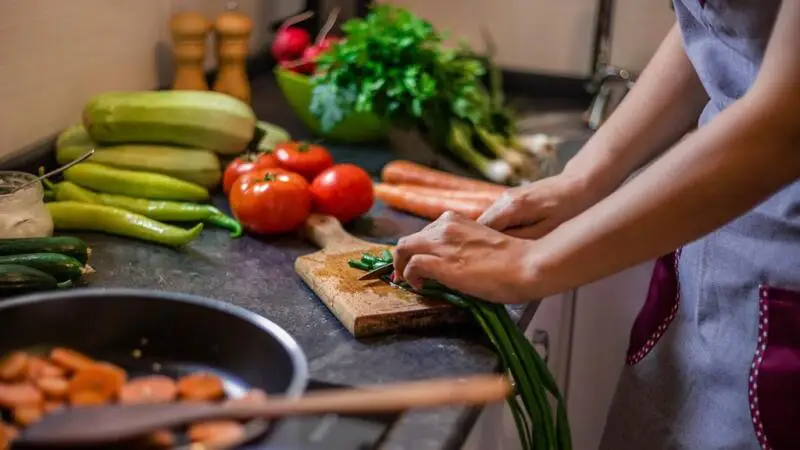 A person chopping up vegetables on a cutting board