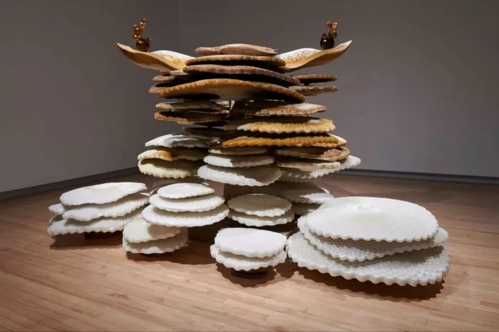 Sculpture of multiple disks with crinkled edges piled randomly on top of one another