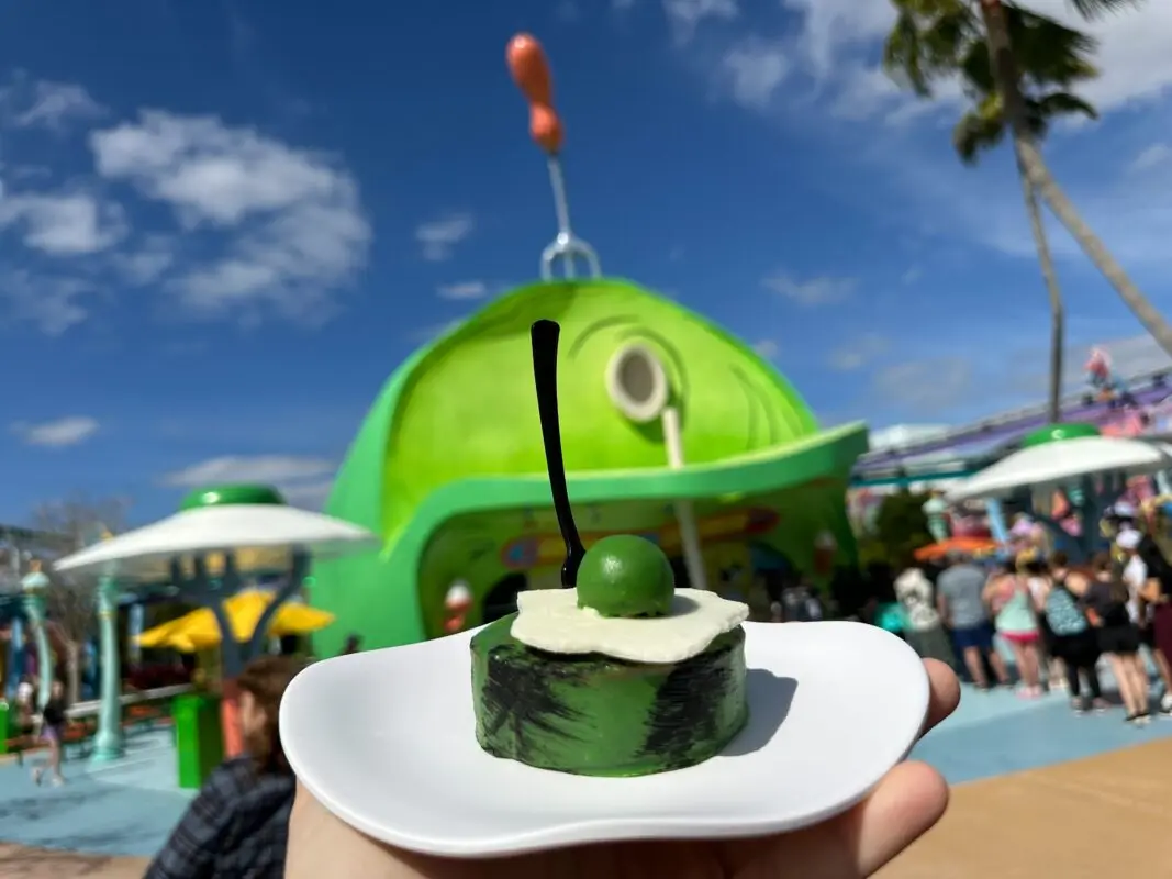 A wide shot of the Green Eggs & Ham Cheesecake outside the Green Eggs & Ham-shaped restaurant