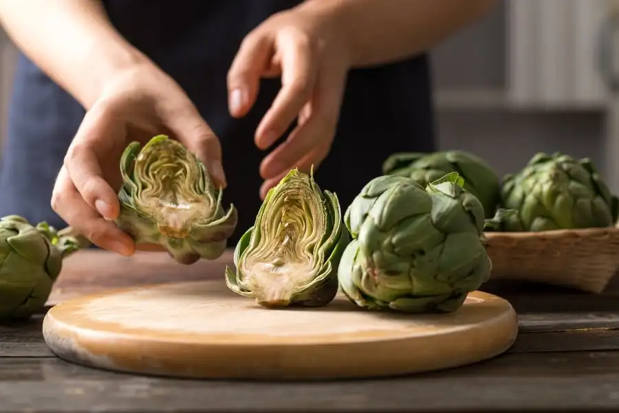 Someone chopping artichokes