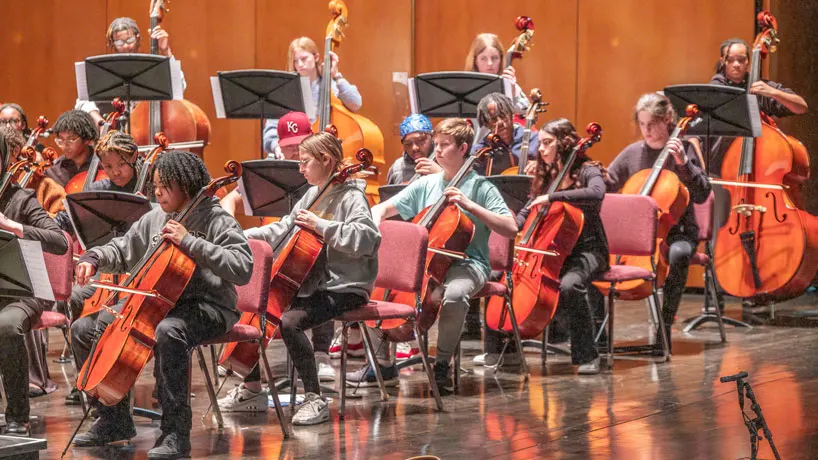 High school students playing string instruments