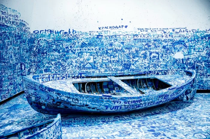 A boat covered in blue graffiti
