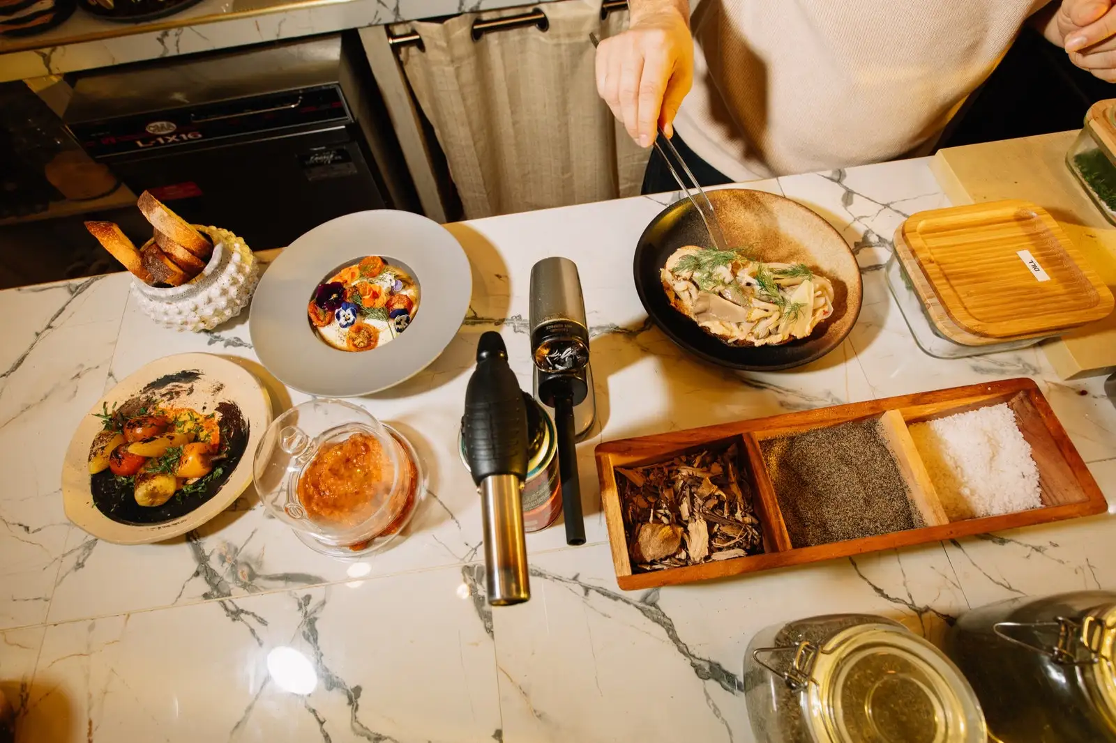 Several plates of food atop a marble surface.