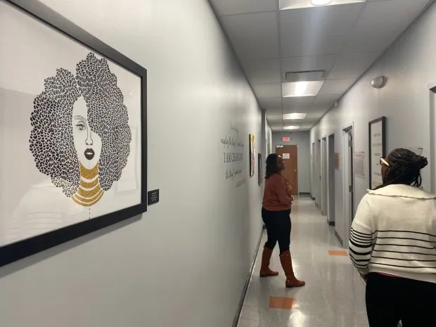 Amber Black, FNP-BC Family Nurse Practitioner [left] jokes with Public Relations Officer Danielle Banks in a hallway of the Village of Healing Center. (Frank Mecham- The News-Herald.)