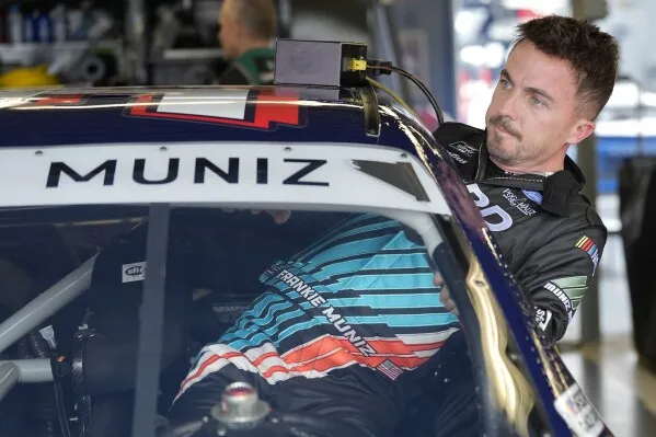 Race car driver and actor Frankie Muniz climbs into his car before a practice run Friday, Feb. 16, 2024, at Daytona International Speedway in Daytona Beach, Fla. Muniz will attempt to make his NASCAR Xfinity Series debut Saturday. (AP Photo/Chris O'Meara)