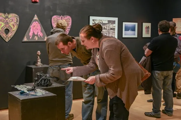 Danny McGinnis and Brianna McGinnis, of New Windsor, look at the art during the opening reception of the 2nd Biennial Carroll Community College Faculty Exhibition.(Karen Jackson/Freelance)