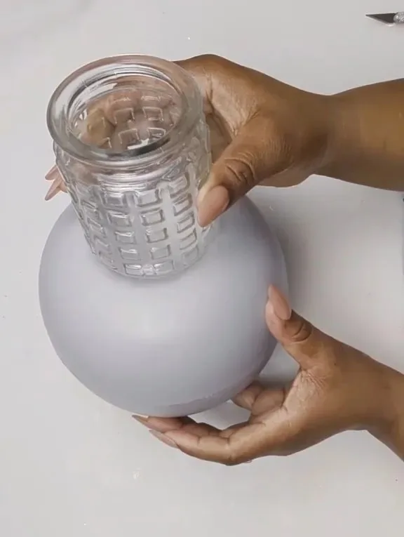 The TikToker placed a Dollar Tree glass on the bowls to create the neck of her DIY vase