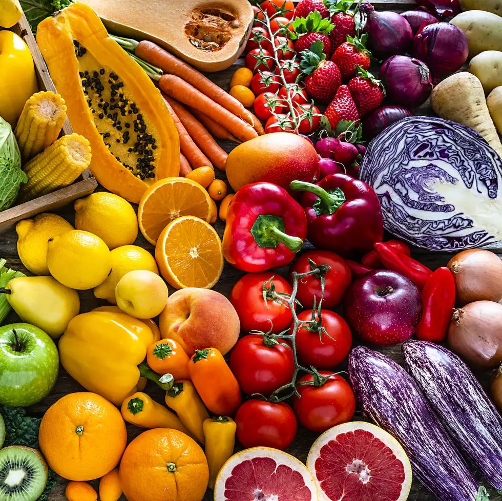 high angle view of a large assortment of healthy fresh rainbow colored organic fruits and vegetables the composition includes cabbage, carrots, onion, tomatoes, raw potato, avocado, asparagus, eggplant, celery, cucumber, broccoli, squash, lettuce, spinach, lemon, apples, pear, strawberries, papaya, mango, banana, grape fruit, oranges, kiwi fruit among others the composition is at the left of an horizontal frame leaving useful copy space for text andor logo at the right high resolution 42mp studio digital capture taken with sony a7rii and zeiss batis 40mm f20 cf lens