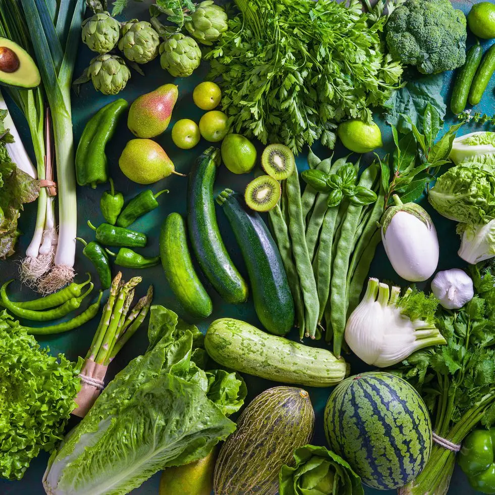 raw fruits and vegetables varied vegan food on monochrome green table full frame background