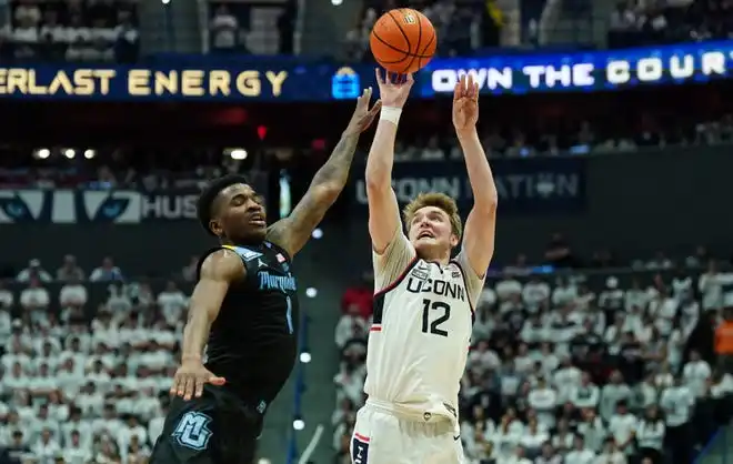 Connecticut guard Cam Spencer (12) shoots against Marquette guard Kam Jones (1) in the second half at XL Center.