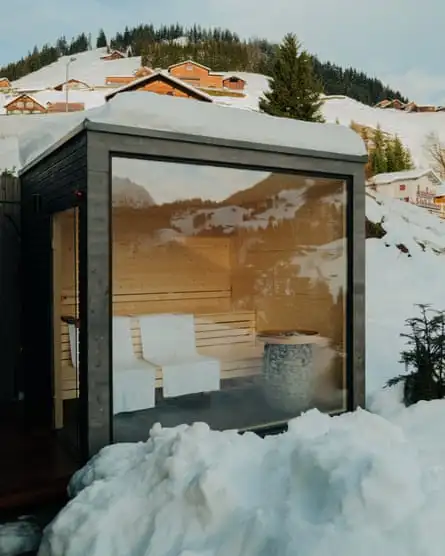 Constructed in dark wood, this small private sauna cabin has huge windows to look out on to the mountains.