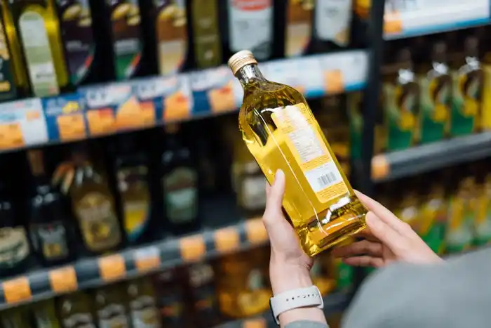 Woman looking at a bottle of cooking oil.