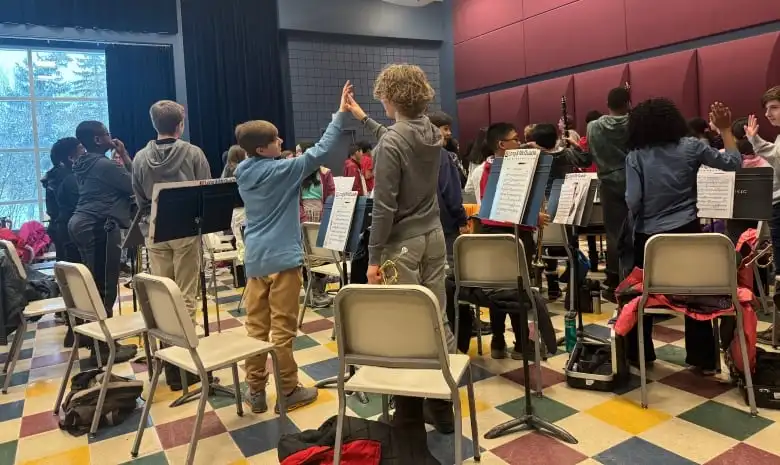 Members of the University of Regina Junior Wind Ensemble give each other high-fives for their hard work in the rehearsal hall on Saturday morning.