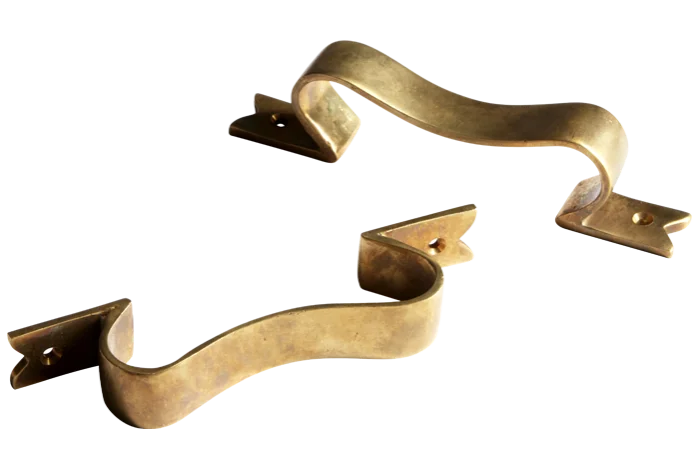 a pair of bow handles made of unlacquered brass