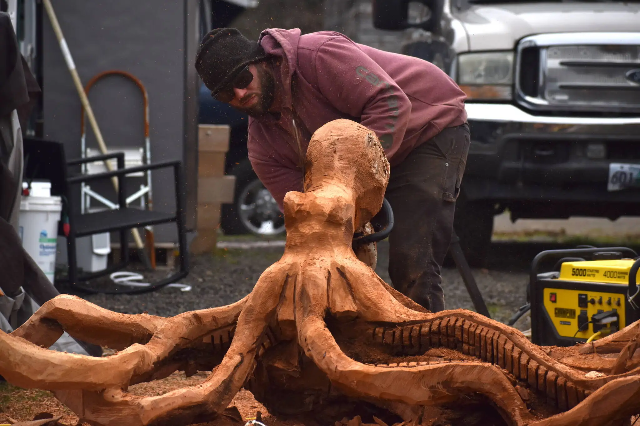 Lane Worden sculpts a wood octopus at the Ocean City Marketplace on Feb. 16. (Clayton Franke / The Daily World)